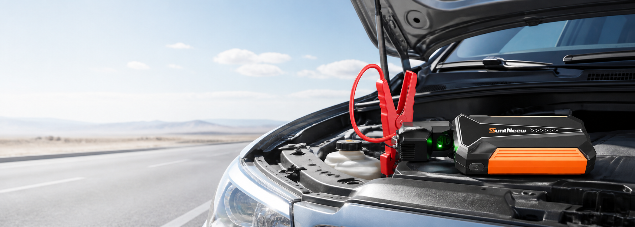 SuntNeew jump starter connected in a vehicle engine bay
