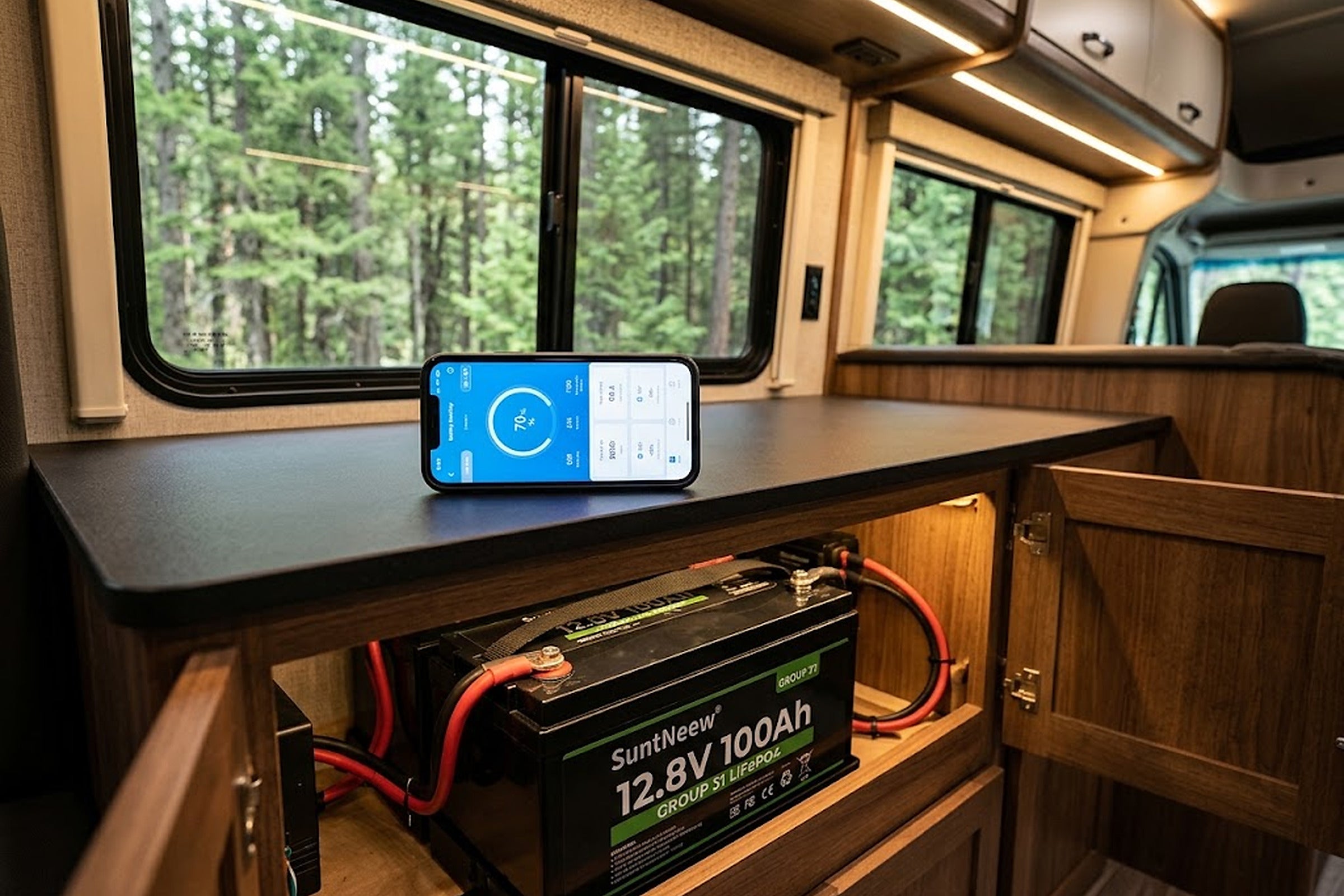 Phone displaying Bluetooth battery status above a SuntNeew Group 31 battery in an RV
